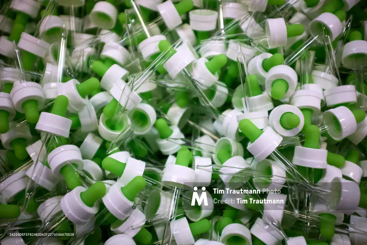A dense accumulation of laboratory droppers with bright green caps and translucent bodies creates an intriguing landscape of scientific waste materials. The glass or plastic pipettes catch ambient light, creating subtle reflections and shadows that emphasize the overwhelming abundance of laboratory supplies. Shot at SCRAP PDX in Portland's Goose Hollow neighborhood, this image captures the raw reality of scientific materials awaiting their next life. The chaotic arrangement suggests both research industry waste and creative potential inherent in repurposed laboratory equipment.