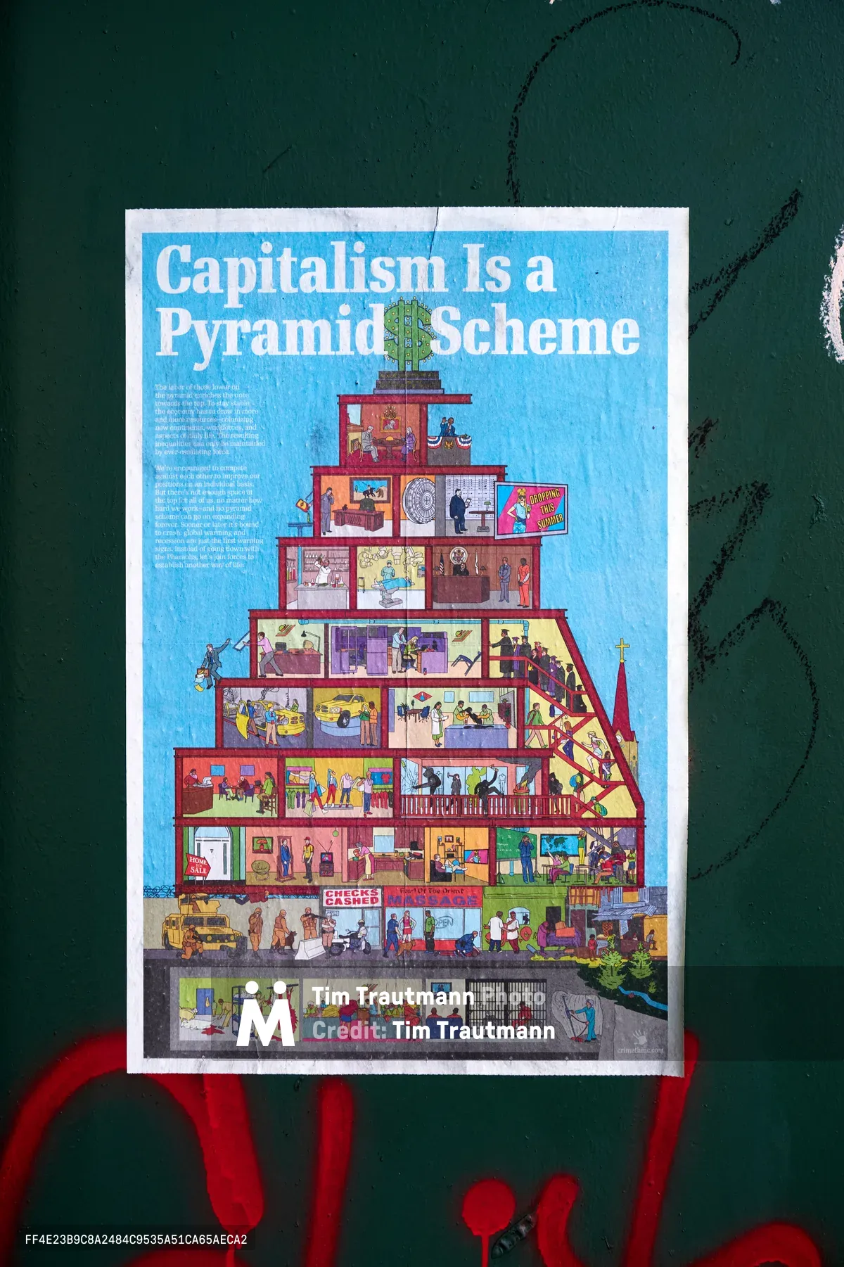 A weathered poster declaring 'Capitalism Is a Pyramid Scheme' adheres to a dark green wall in Portland's Concordia neighborhood, its edges worn from exposure. The detailed illustration depicts a multi-tiered pyramid structure with colorful cross-sections showing different socioeconomic levels, from luxury penthouses crowned with dollar signs at the top to cramped basement conditions at the bottom. Red graffiti marks streak beneath the poster, creating a stark contrast against the emerald backdrop while emphasizing the raw, urgent nature of this pandemic-era street commentary.
