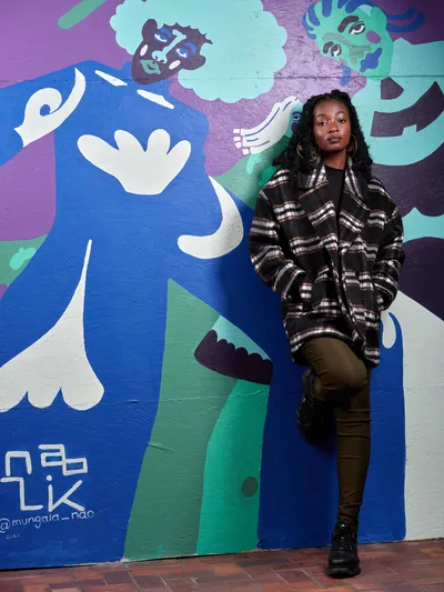 Artist Naomi Likayi Against Her Vibrant Mural