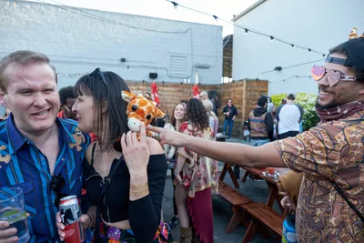 Playful Giraffe Puppet Encounter at Summer Party
