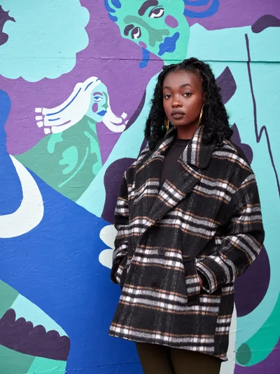 Artist Naomi Likayi Against Vibrant Mural