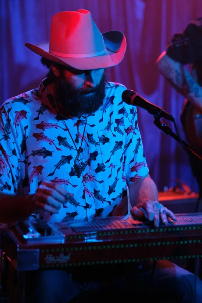 Neon-Soaked Performer Lost in Musical Reverie