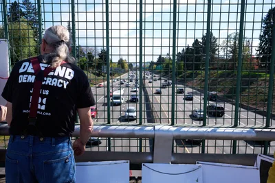 Democracy Activist Overlooks Highway During Portland Banner Drop