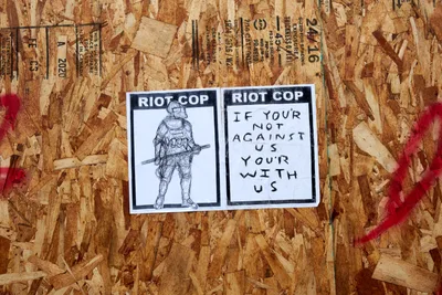Riot Cop Stickers on Boarded Storefront