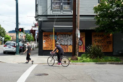 Cycling Past Boarded Storefronts on Hawthorne