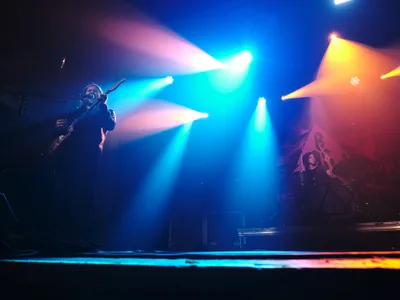 Russell Marsden and Julian Dorio of Band of Skulls perform during their 10 Year Anniversary Tour at Webster Hall in Manhattan's East Village. Intense cyan and amber stage lights slice through the atmospheric darkness, creating dramatic beams that illuminate the musicians in silhouette. The legendary venue's intimate setting amplifies the raw energy as the duo delivers their signature sound beneath the venue's historic ceiling, with stage smoke adding ethereal texture to the lighting design.